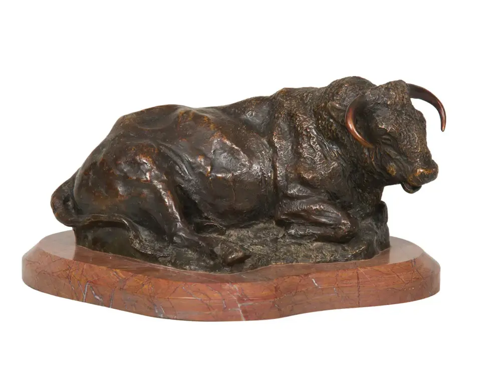 Bronze sculpture of a crouching bull on a round wooden pedestal