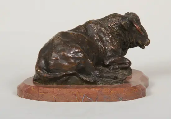 Bronze sculpture of a resting bull on a circular marble base.