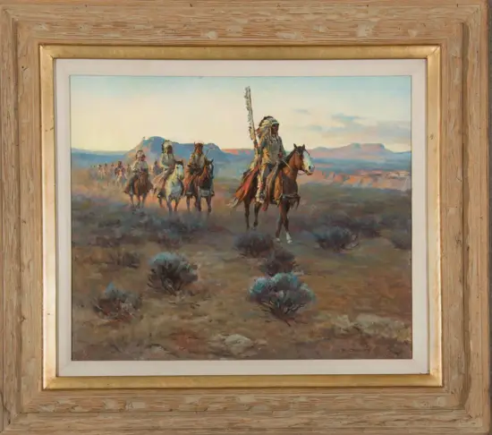 A line of Native American riders on horseback moving across a desert plain with distant mesas. The lead rider carries a tall feathered staff.