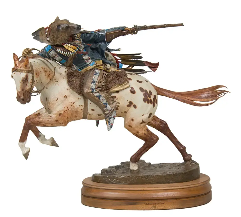 Decorative statue of a rider on a spotted horse aiming a rifle while galloping, mounted on a wooden base.