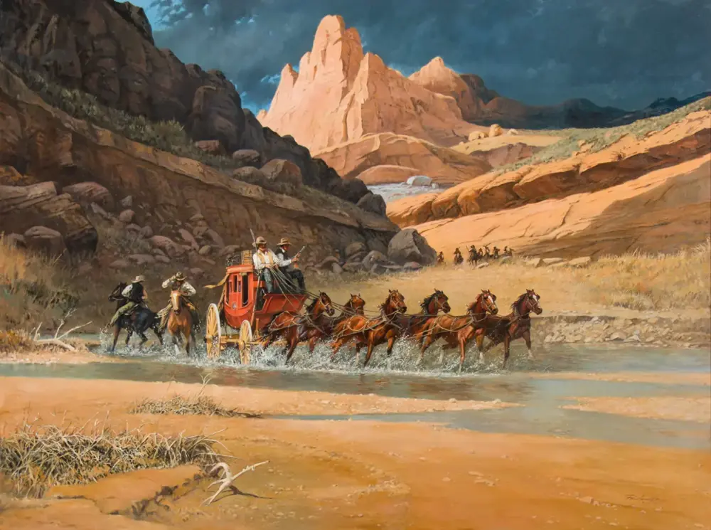 Red stagecoach with passengers crossing a shallow river, pulled by a team of horses as rugged orange cliffs loom in the background.