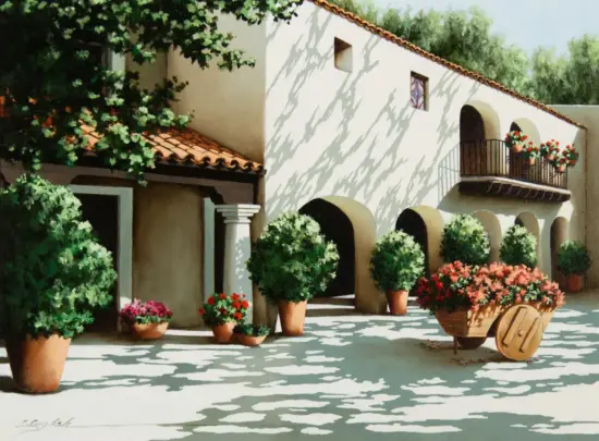 Sunlit Mediterranean courtyard with white stucco walls, terracotta roof tiles, arched doorways, and many potted plants, including a flower-filled wheelbarrow in the foreground.