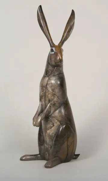 Stone sculpture of a rabbit standing upright on its hind legs with long ears and marbled texture.