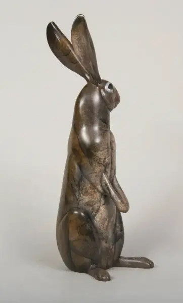 Bronze sculpture of a seated rabbit with long ears, textured marbled surface.