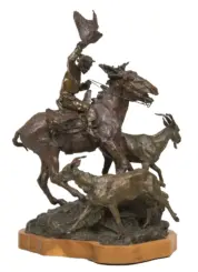 Bronze sculpture showing a rider on a rearing horse wielding a flag, with another horse and figures around on a rocky base on a wooden pedestal.