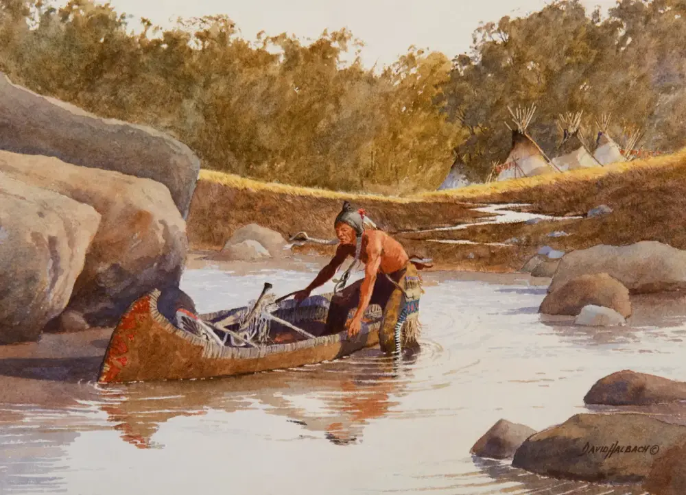 Native American man in traditional attire guides a decorated canoe along a shallow river with rocks and trees in the background, tents visible beyond the bank.