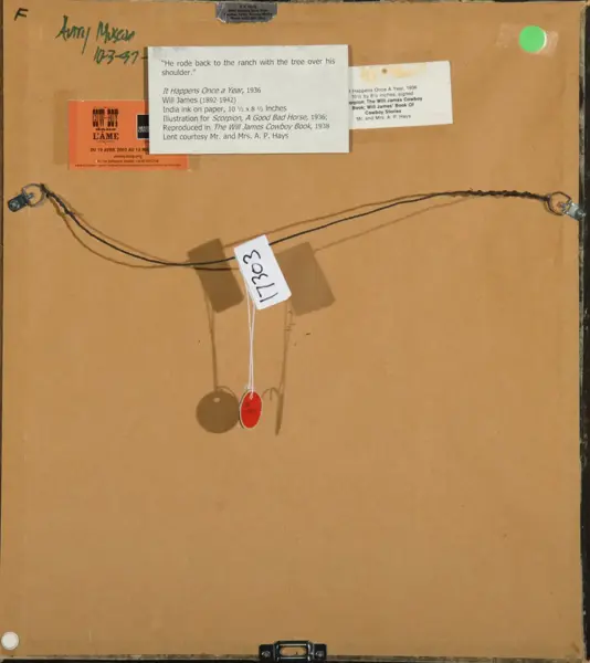 Back of a framed artwork: brown backing board with a twisted hanging wire along the top, metal anchor brackets at left and right, several labels and stickers, a white tag with handwritten number hanging from the center, and two small pendant tags (red and brown) dangling below. A small green sticker is in the top-right corner.
