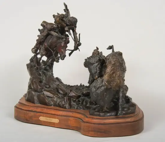 Bronze sculpture on a wooden base showing two intertwined, jagged figures in a dynamic, dramatic pose with dark patina.