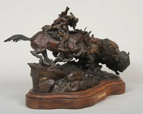 Bronze sculpture of a rider on a rearing horse on a wooden base.