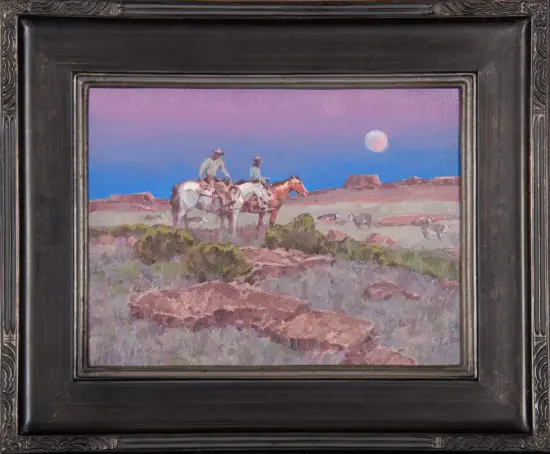Desert landscape with three cowboys on horseback at dusk, pink to blue sky and a full moon, in a decorative frame.