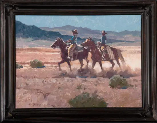 Three riders on horseback gallop across a dusty desert with distant mountains under a blue sky, in a dark framed painting