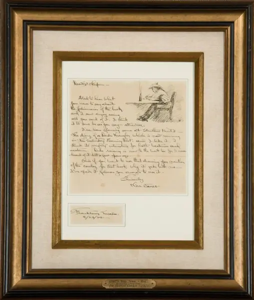 Framed display of a handwritten letter with a small sketch at the top right, mounted on beige matting in a gold-toned frame.
