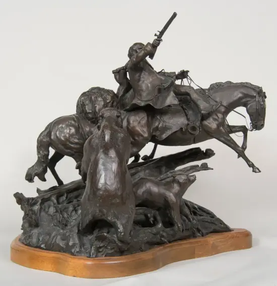 Bronze sculpture showing a mounted rider raising a gun, surrounded by charging horses on a jagged rocky base.