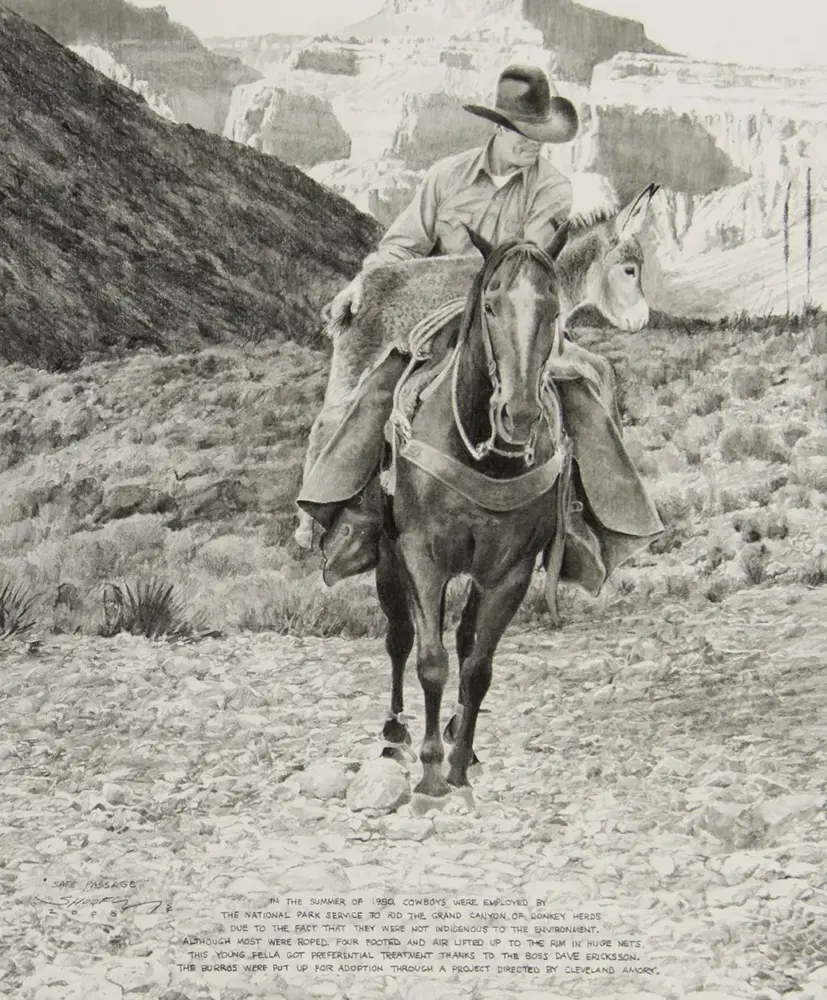 Cowboy rides a horse along a rocky trail in a desert canyon with a donkey resting in the background.