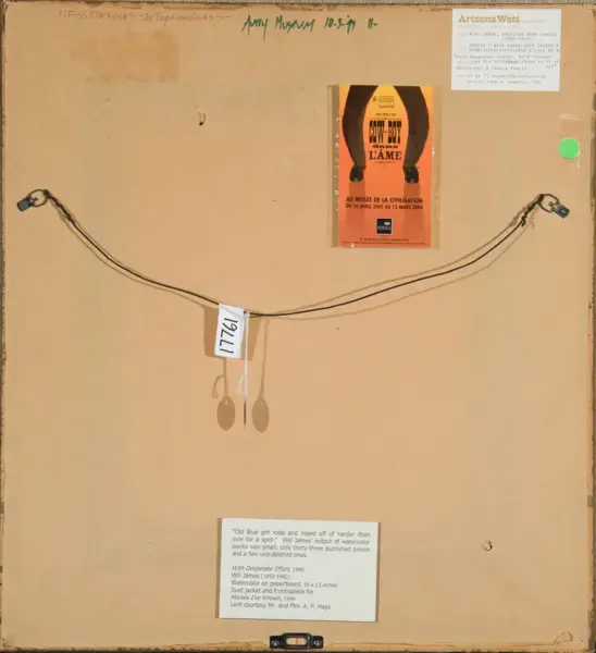 Beige gallery panel with two cords looped in a shallow arch across the middle, a white tag hanging from the center, and an orange exhibition poster taped toward the upper center; small labels appear at top-right and bottom.