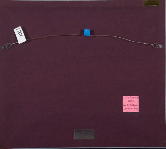 Curved metal necklace or bracelet with clasps at both ends on a purple display board, blue tape securing the middle section and a pink note nearby.