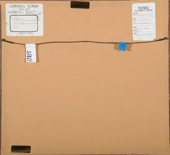 Back of framed artwork with hanging wire across the top; left is a Cornell Norby Fine Art label, right is a Desert Caballeros Western Museum label, with a small blue tape near the wire.
