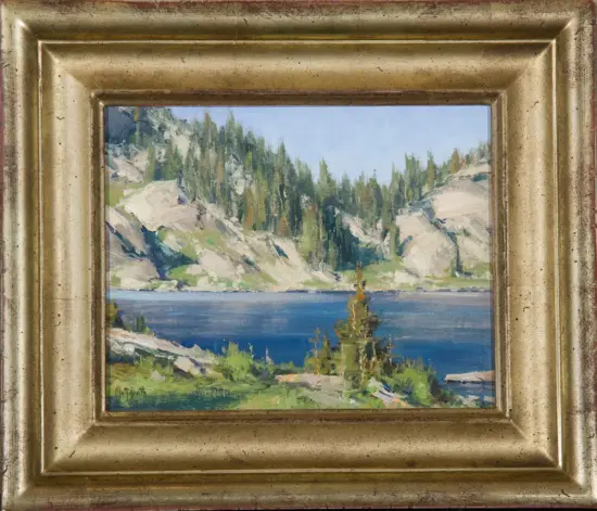 Landscape painting of a lake with forested hills and rocky cliffs, housed in a gold ornate frame.