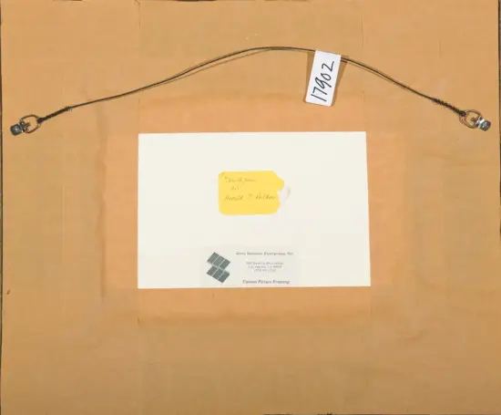 Back view of a framed picture: a curved cord with metal end hooks attached to a brown board, white mat, and a yellow tag with handwritten notes.