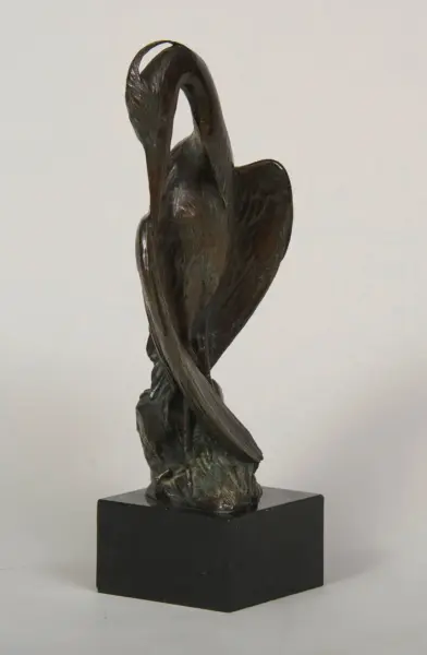 Abstract bronze sculpture of a bird with a curved neck on a square pedestal, dark patina and textured wings.