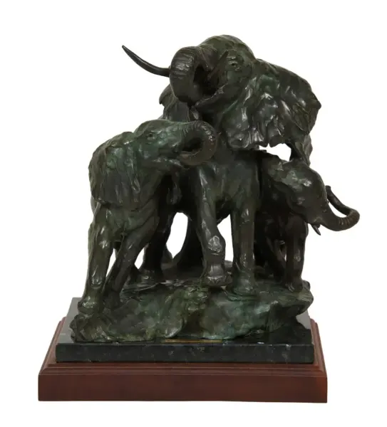 Bronze sculpture of three elephants with trunks raised, perched on a dark stone base atop a wooden plinth.
