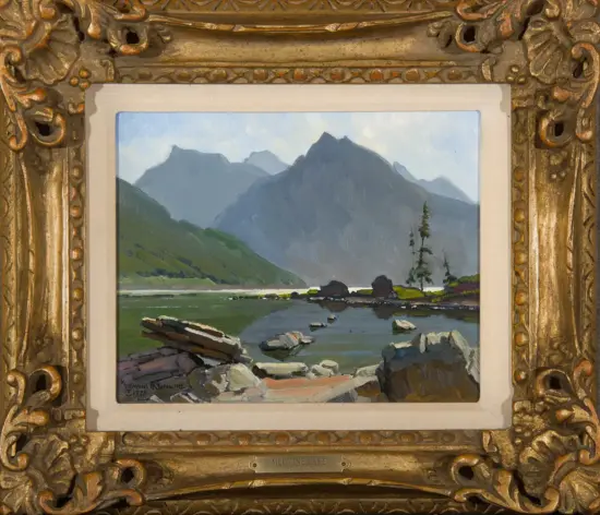 Framed landscape painting of Medicine Lake: mountains, calm lake, rocks in foreground and a tall tree on the shore.
