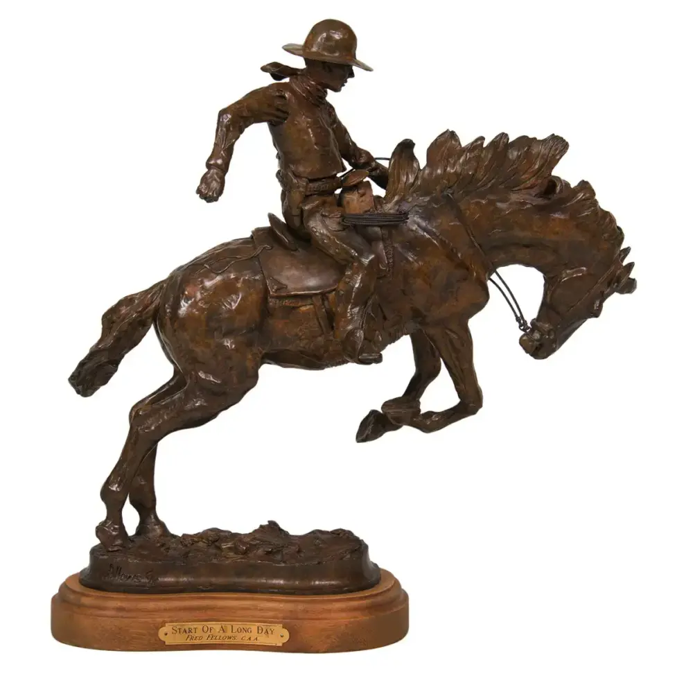 Bronze equestrian sculpture of a cowboy riding a bucking horse on a wooden base, title plaque reads 'Start Of A Long Day'