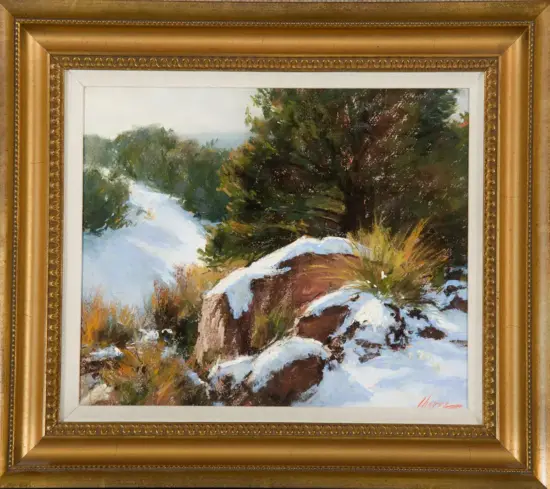 Oil painting of a snow-covered hillside with rocks and evergreen shrubs, in a gold frame.