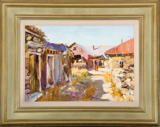 Framed impressionist painting of a sunlit village street with colorful buildings and a dirt path.