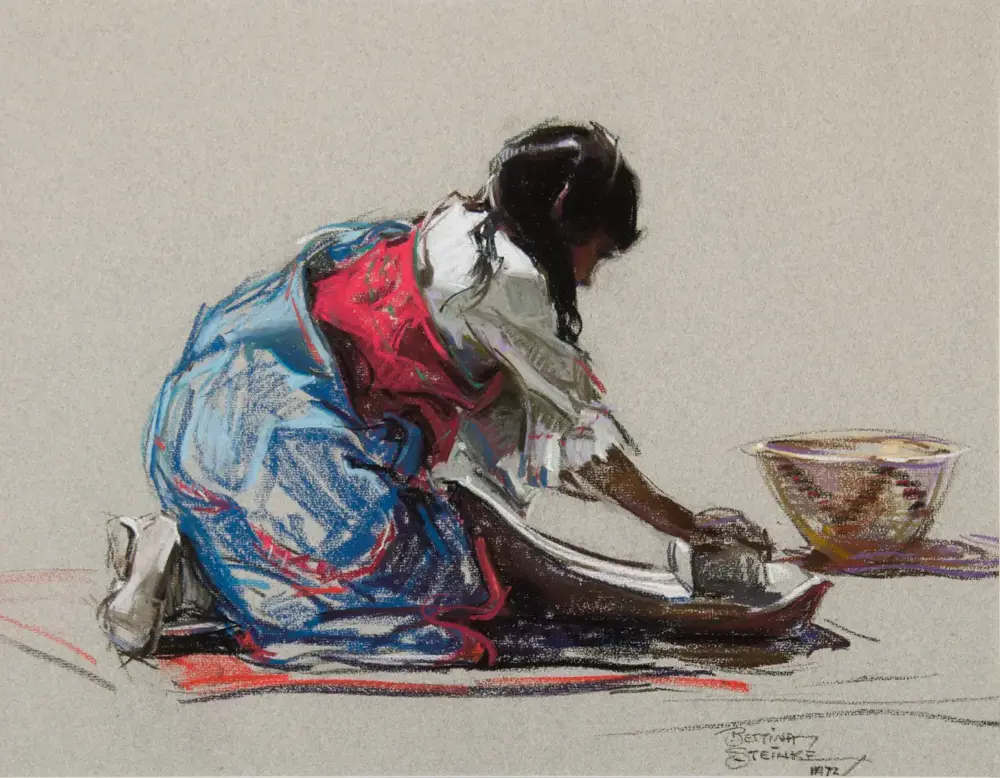 Woman kneeling and washing clothes by hand beside a bowl on a neutral background; colorful traditional dress in blue and red dominates the scene