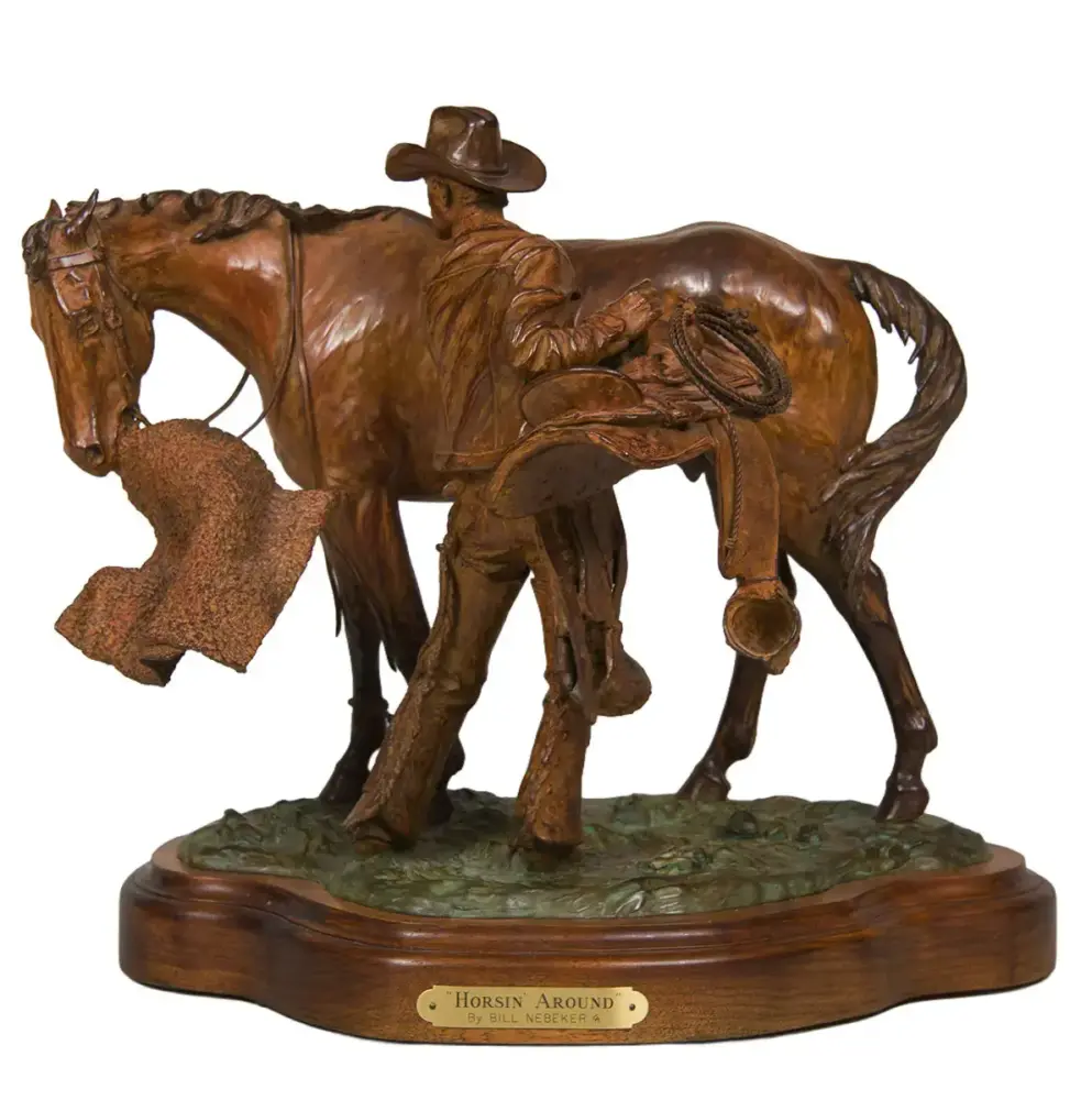 Bronze-toned sculpture of a cowboy with a rope beside a horse on a wooden display base, titled 'Horsin Around'.5
