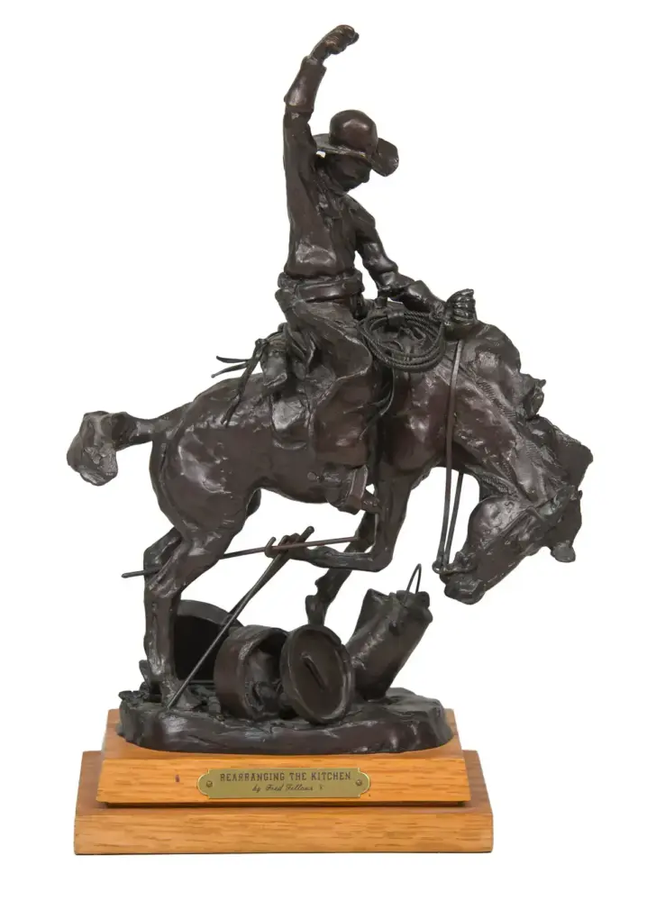 Bronze sculpture of a cowboy riding a bucking horse, rope in hand, mounted on a wooden base with a plaque.
