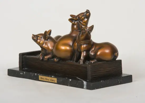 Bronze sculpture of three pigs on a dark wooden base, with a plaque reading 'Three Place Setting'.