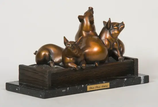 Bronze sculpture of three pigs lounging on a dark wooden pedestal with a plaque reading 'Three Place Setting' at the front.