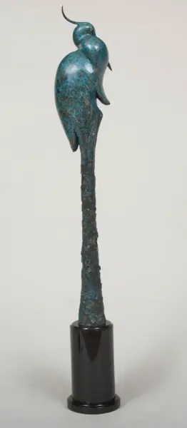 Turquoise-blue bird sculpture perched on a tall, textured column with a black base.