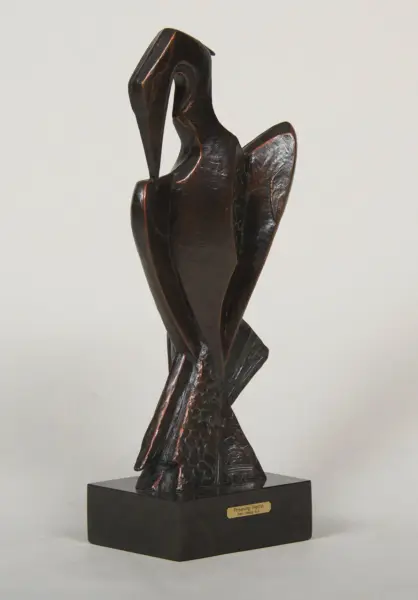 Bronze sculpture of a preening heron on a black pedestal base with a small plaque