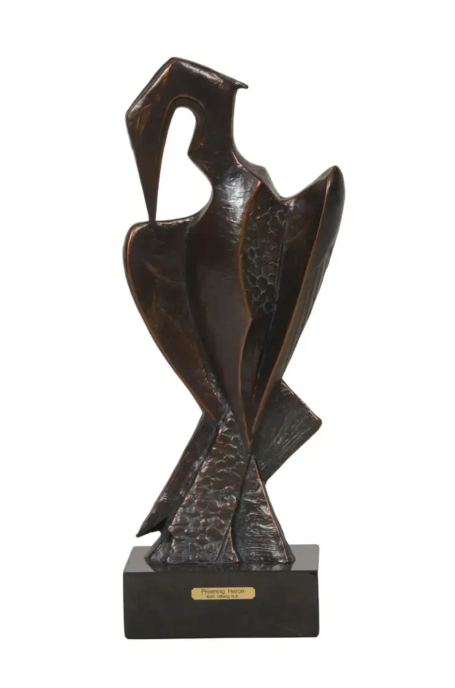 Bronze sculpture of a preening heron on a black pedestal with a small plaque on the base.