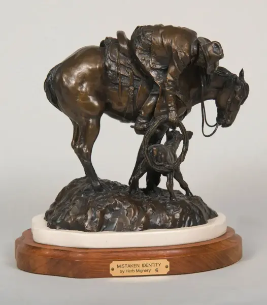 Bronze sculpture titled 'Mistaken Identity' by Herb Mignery, showing a horse with a rider and lasso on a wooden base.