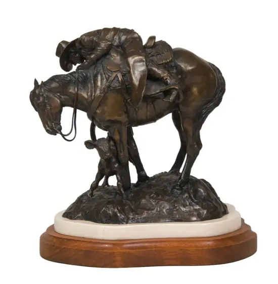 Bronze sculpture of a horse and rider with a small child standing beside them, mounted on a wooden pedestal.