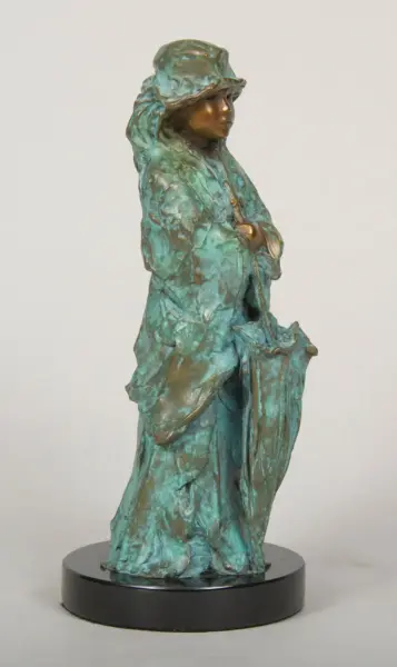 Bronze-green statue of a woman in a long cloak and wide-brim hat, standing on a black circular base.