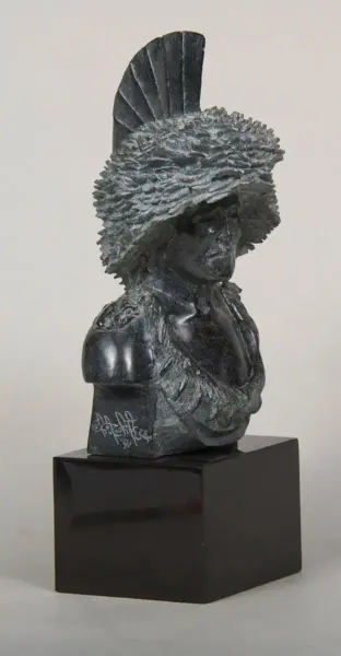 Stone bust of a man wearing a large feathered war bonnet on a black pedestal