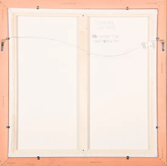 Back of a framed canvas with a hanging wire, pale wood stretcher bars, and a handwritten note reading 'SCHENCK July 2024 UNDER THE SHELTERING SKY'