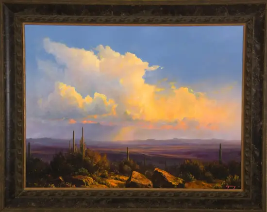 Desert landscape at sunset with tall cacti, rocks, and a colorful sky framed by an ornate dark picture frame (art painting).
