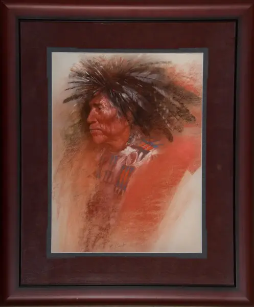 Framed portrait of a Native American man in a feather headdress, shown in profile with warm reddish-brown tones; framed art print.