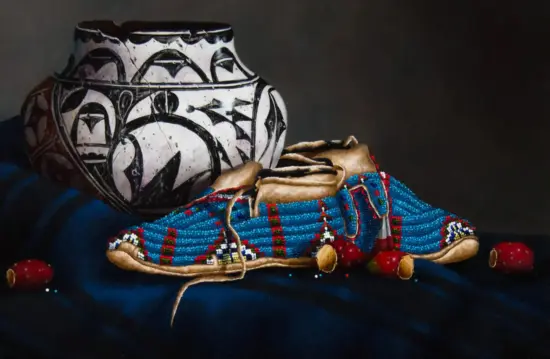 Large ceramic vase with a bold black pattern sits on a bright blue beaded textile and a tan leather pouch, against a dark background.