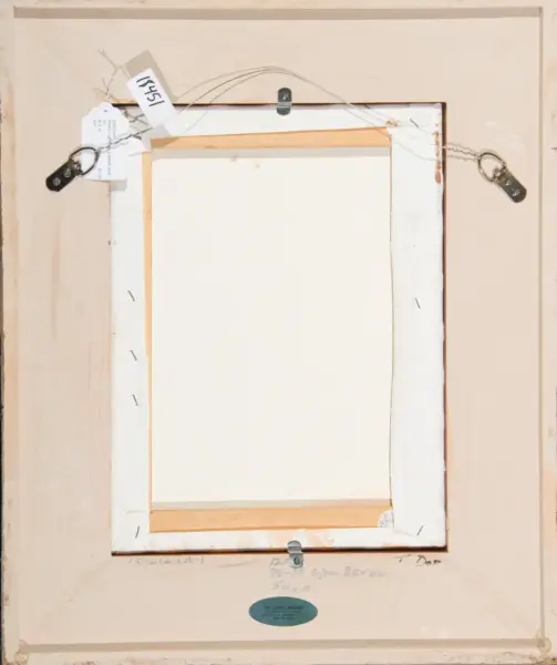 Back of a framed painting showing hanging wire, D-rings, and corner supports with a blue oval label at the bottom edge of the frame.