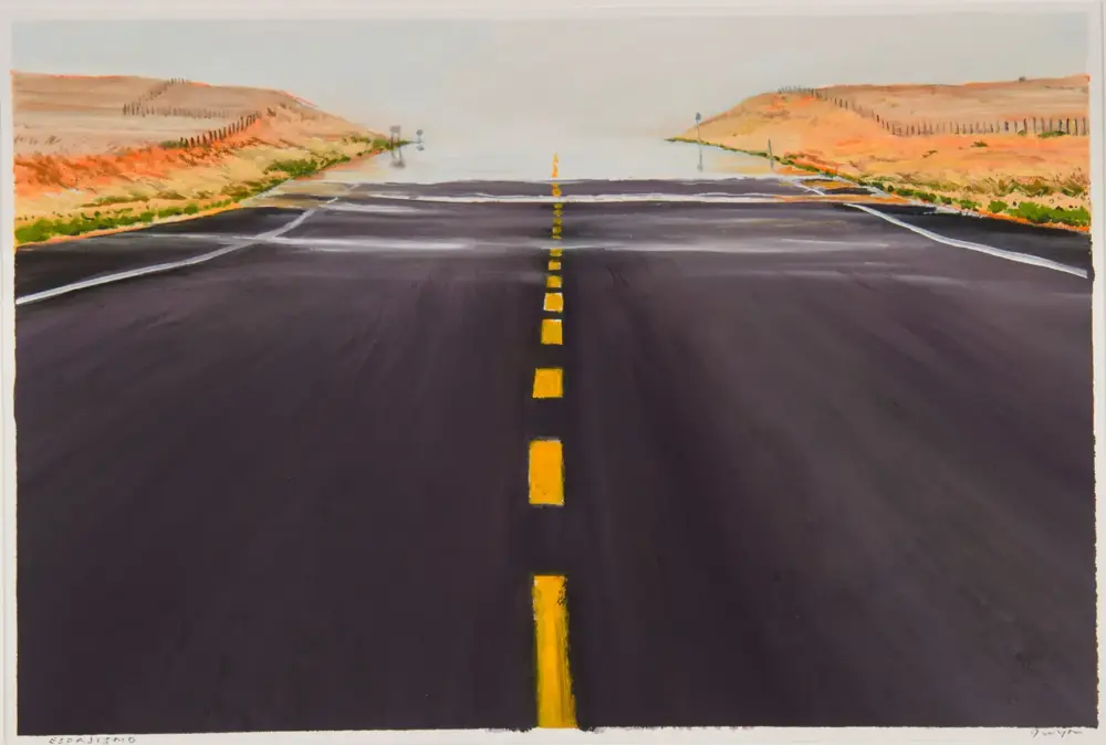 Wide perspective of a straight, dark road with a yellow dashed center line fading to a distant horizon, flanked by orange desert hills on both sides.