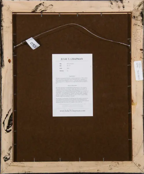 Back of a framed artwork with a curved hanger wire and a printed sheet labeled 'JULIE T. CHAPMAN' on brown backing.