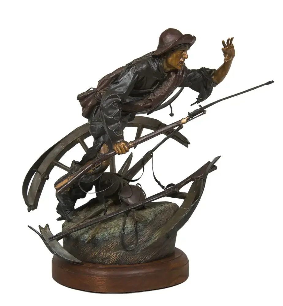 Bronze sculpture of a frontiersman in a hat, leaning forward and holding a rifle, mounted on a rocky pedestal with a wooden base.