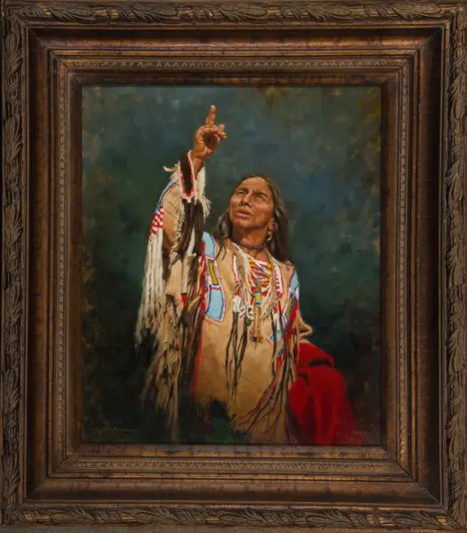 Framed portrait of a Native American man in fringed clothing raising his right hand with index finger pointing upward.